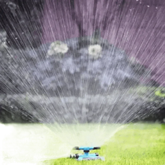 Blue Rotating Garden Sprinklers Watering Grass